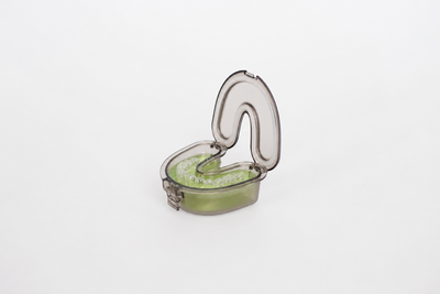 A retainer soaking in prepared Blakmint solution inside the Blakmint Cleaning Case